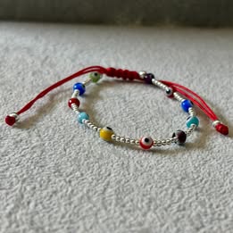 PULSERA AJUSTABLE HILO ROJO BOLITAS LISAS CON OJITO MULTICOLOR, PLATA .925