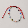PULSERA AJUSTABLE HILO ROJO BOLITAS LISAS CON OJITO MULTICOLOR, PLATA .925
